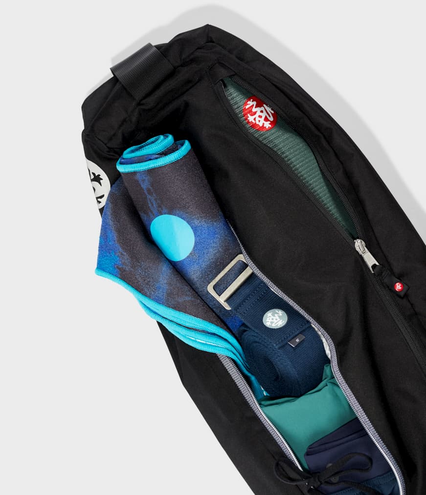 Manduka Go Steady 3.0 Mat Bag - Black - filled with yoga mat, strap & towel, zips half undone | Manduka NZ