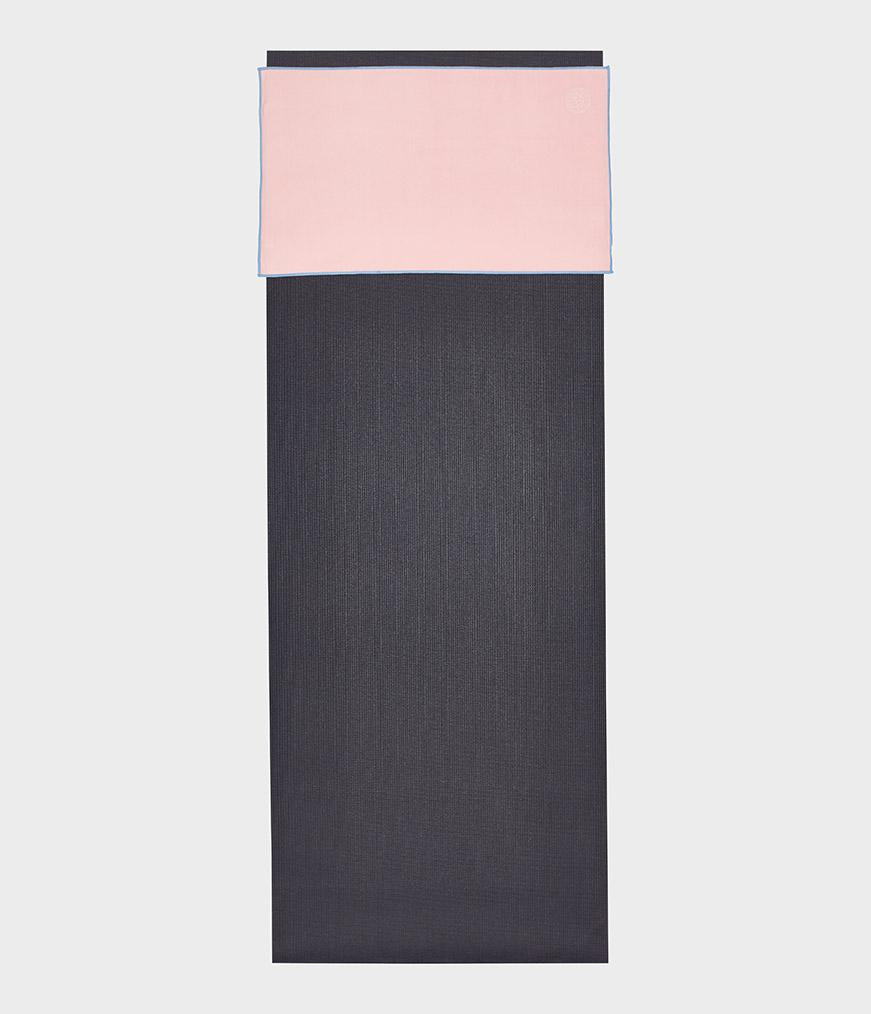 Manduka eQua Hand Towel - Coral - placed on a yoga mat | Manduka NZ